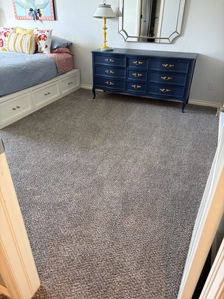 New gray-beige carpet installed in a furnished bedroom